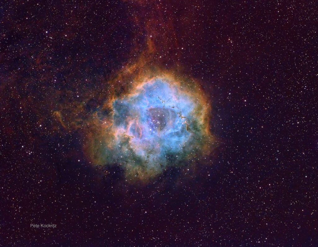 The Rosette Nebula. A gaseous nebula with blue center and orange outer layers.
